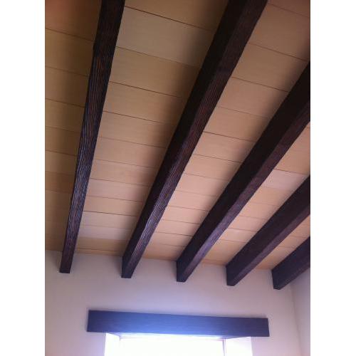 Interior con vigas de hormigón imitación madera rústicas en color nogal.