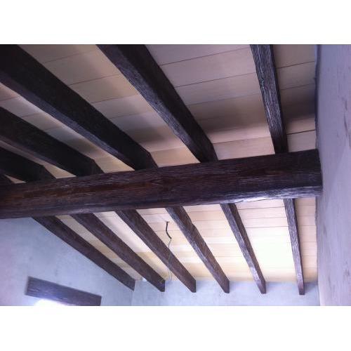 Interior with rustic imitation wood concrete beams in walnut color.